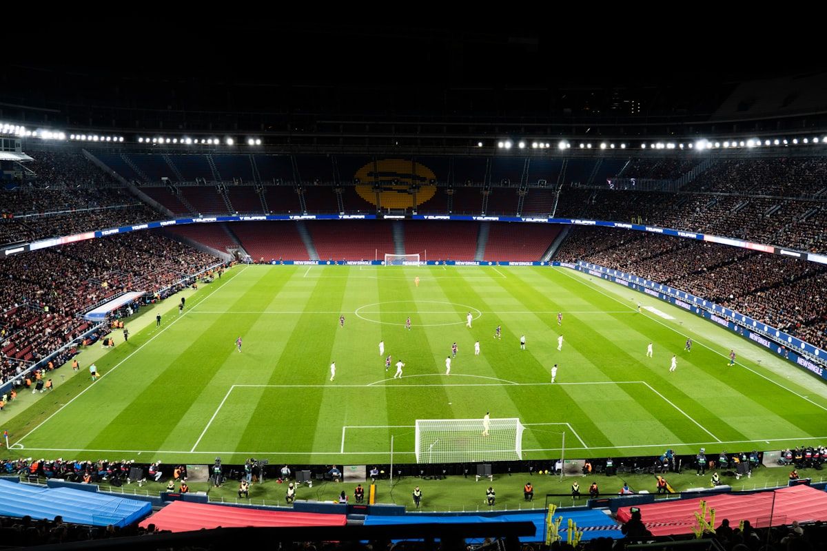 Pertandingan sepak bola di stadion terang benderang