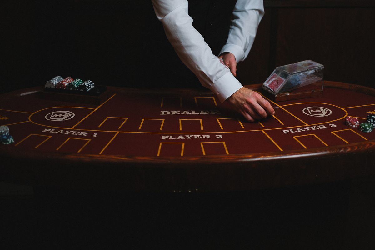 Tangan bandar membagikan kartu di meja blackjack